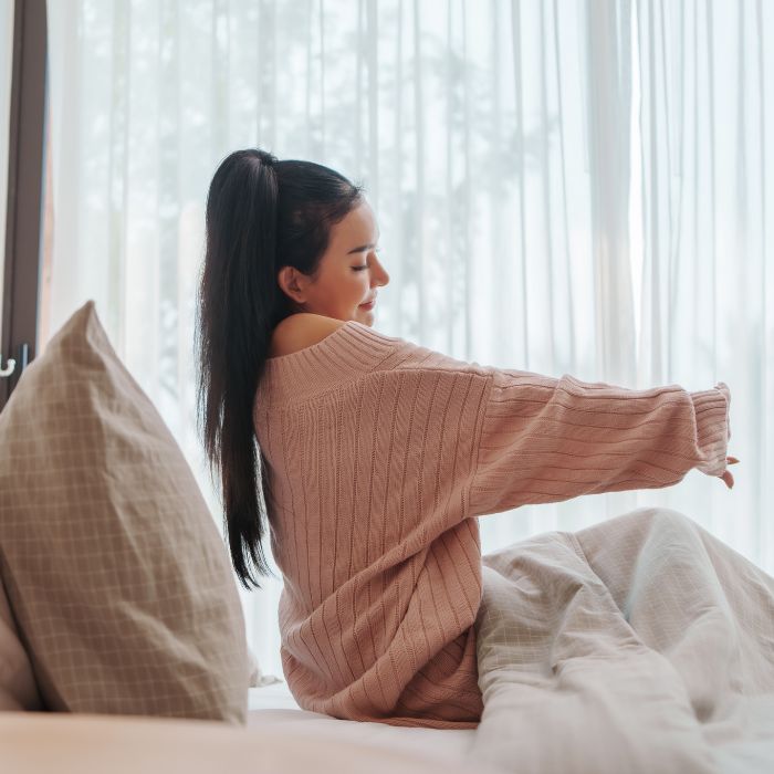 VROUW-DIE-ZICH-UITSTREKT-BIJ-HET-ONTWAKEN