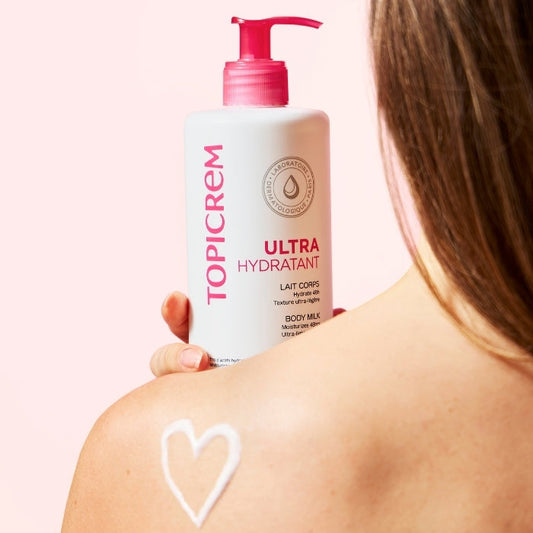 Une jeune femme nous montre son produit préféré le ULTRA-HYDRATANT Lait Corps qui a un impact sur son bien-être