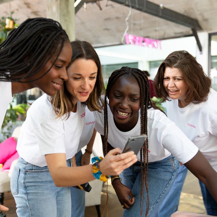 MEERDERE-VROUWEN-KIJKEN-NAAR-EEN-TELEFOON