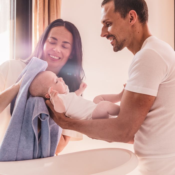 EEN-MAN-EN-EEN-VROUW-DIE-HUN-BABY-VASTHOUDEN-EN-ZIJN-HOOFDHUID-AFDROGEN