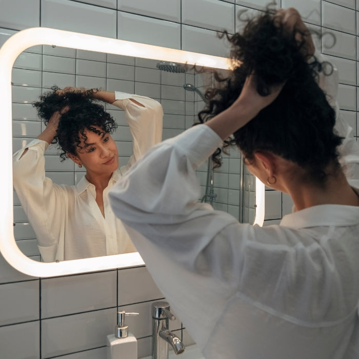 VROUW-MET-KRULLEND-HAAR-DIE-EEN-KNOT-MAAKT