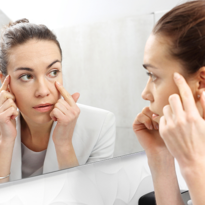 De-gevoelige-huid-vrouw-die-haar-gezicht-bekijkt