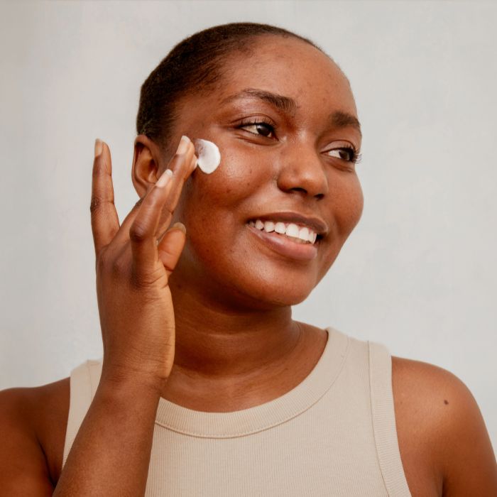 VROUW-MET-ACNE-DIE-CRÈME-AANBRENGT