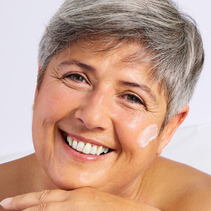 Glimlachende-vrouw-crème-op-gezicht